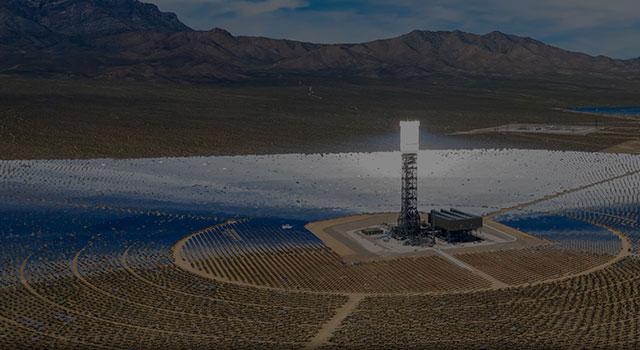 Desert landscape with hundreds of solar-tracking heliostat panels.