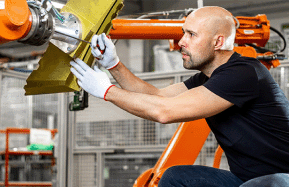 Engineer repairing an automatic robot arm in automotive, smart factory